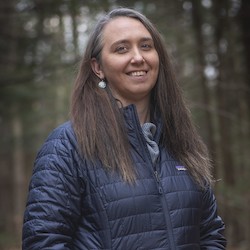 A photo of Desiree Narango with a wooded background