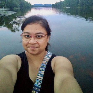 Meghadeepa Maity, standing before a river lined with trees