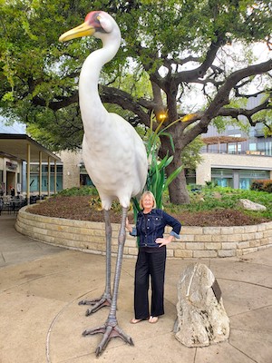 Heather Roskelley posing with an oversize crane statue