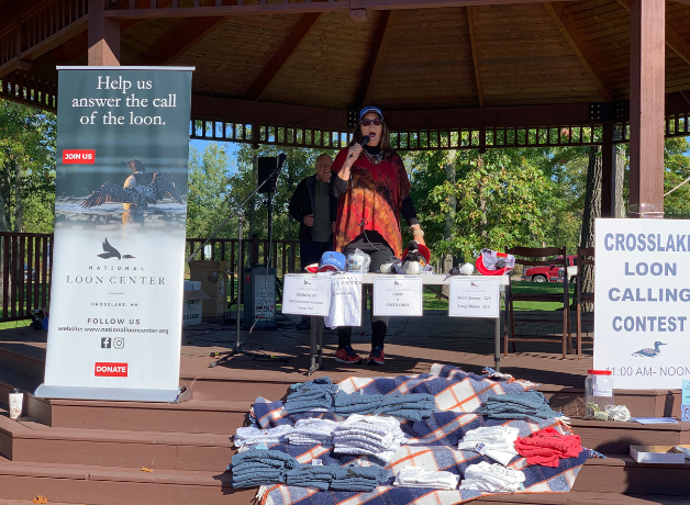 A loon calling competition contestant performs on a gazebo