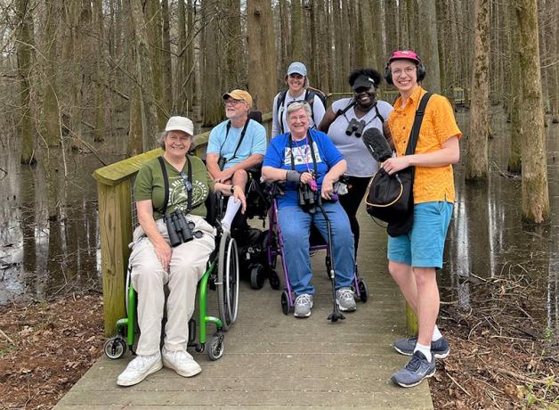 Birdability group members pose together on a birding trip with Bring Birds Back podcast host Tenijah Hamilton and BirdNote producer Mark Bramhill
