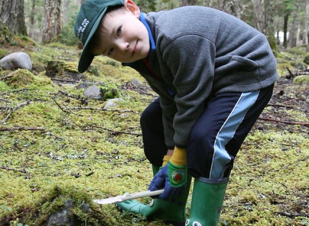 A young volunteer helping maintain a park
