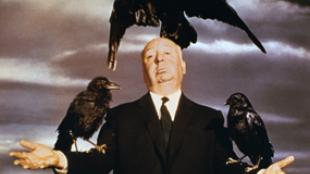 Alfred Hitchcock posing with crows on his arms