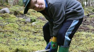 A young volunteer helping maintain a park